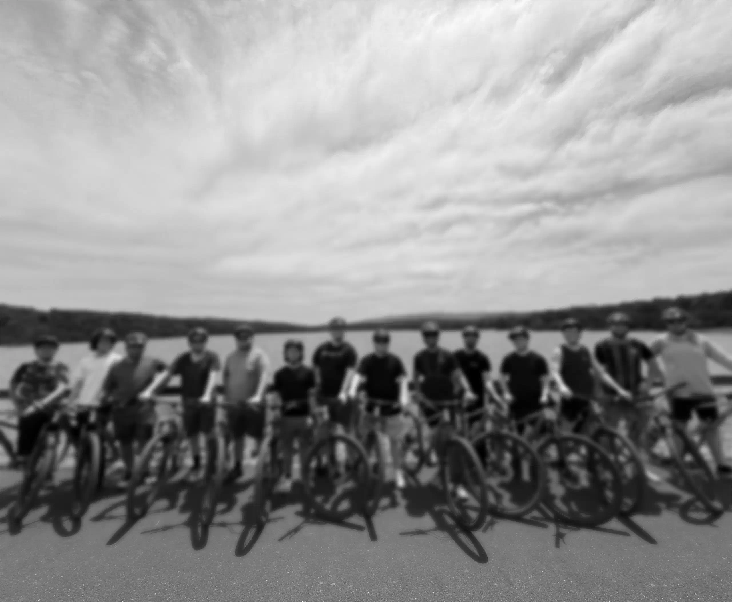 The team with their bikes beside a lake.